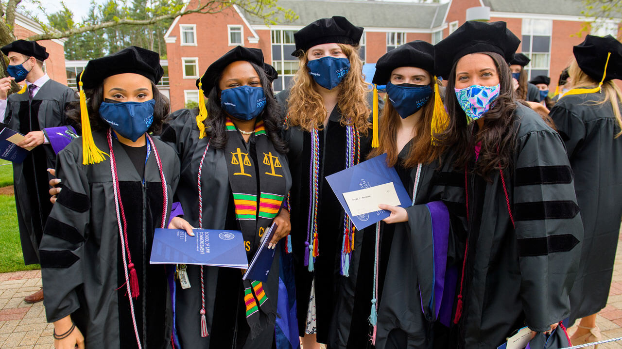 Graduates embrace and pose for a photo