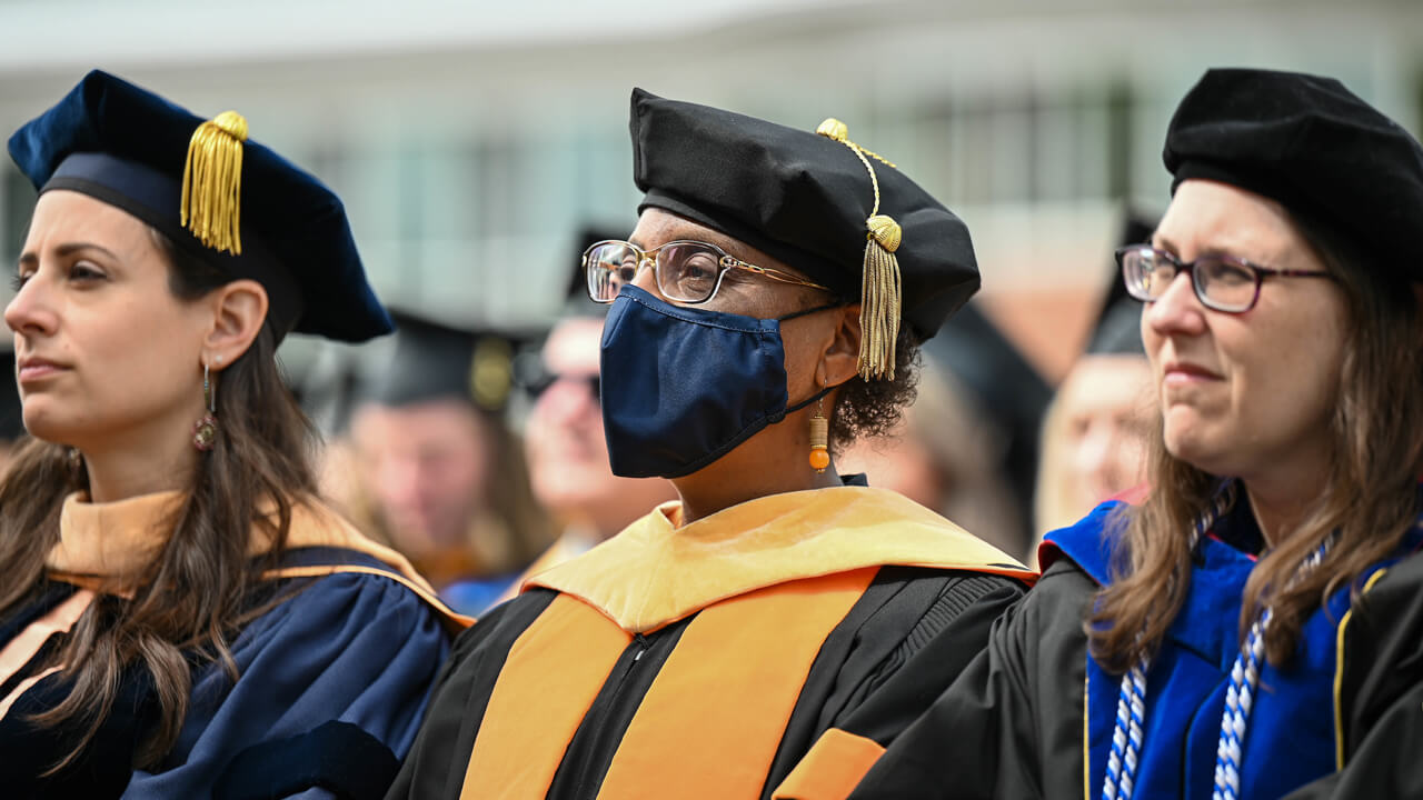 Two faculty members sitting during Commencement