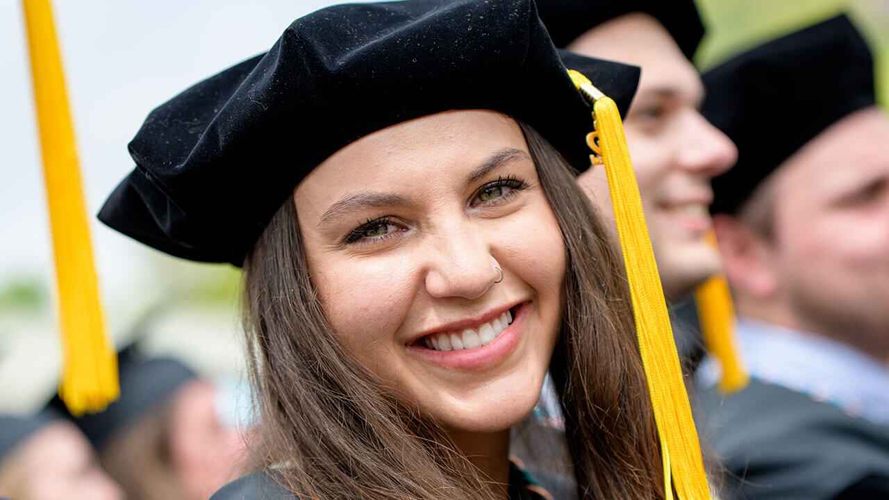 Graduate smiles at the camera