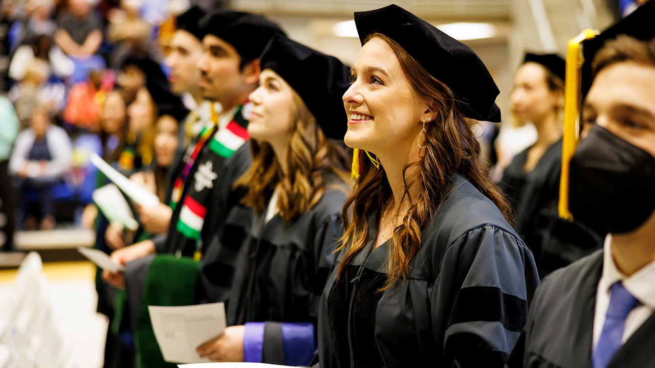 A graduate smiles towards the stage