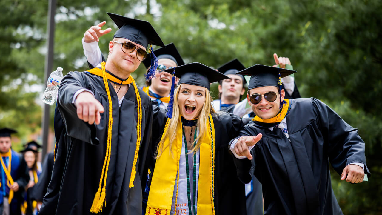 Five graduates pose for a picture with excitement