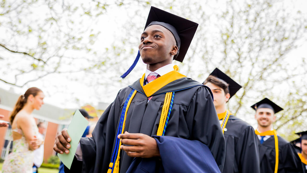 Graduate student looks off into the distance as he walks