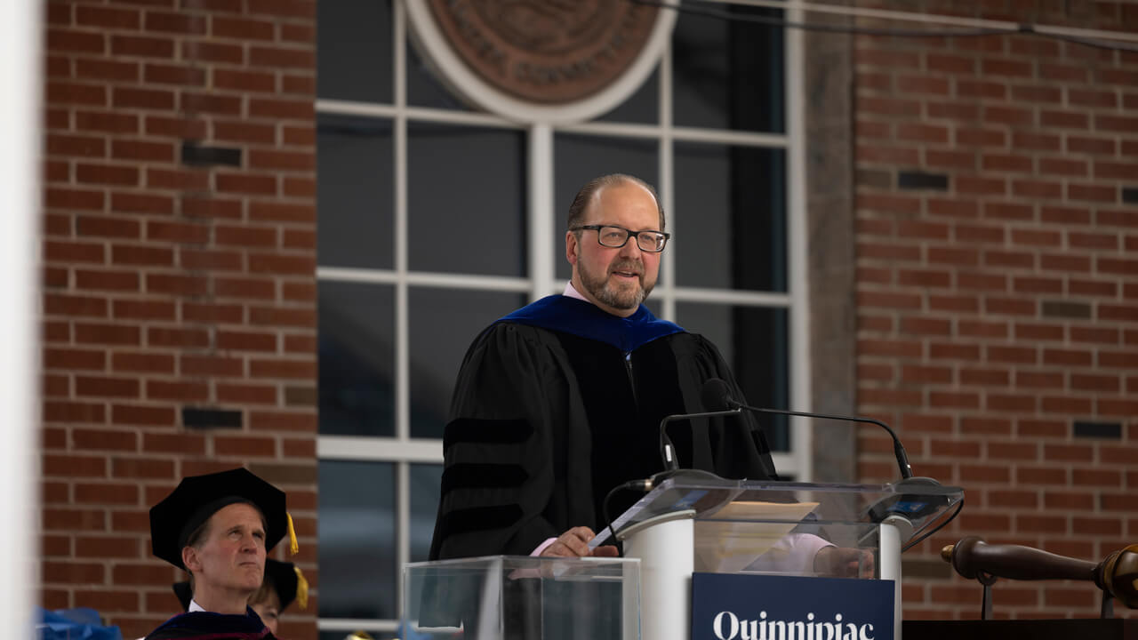 Paul Lavoie speaks to graduate students from a podium