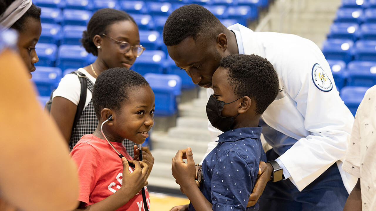 Children play with a stethoscope at the ceremony