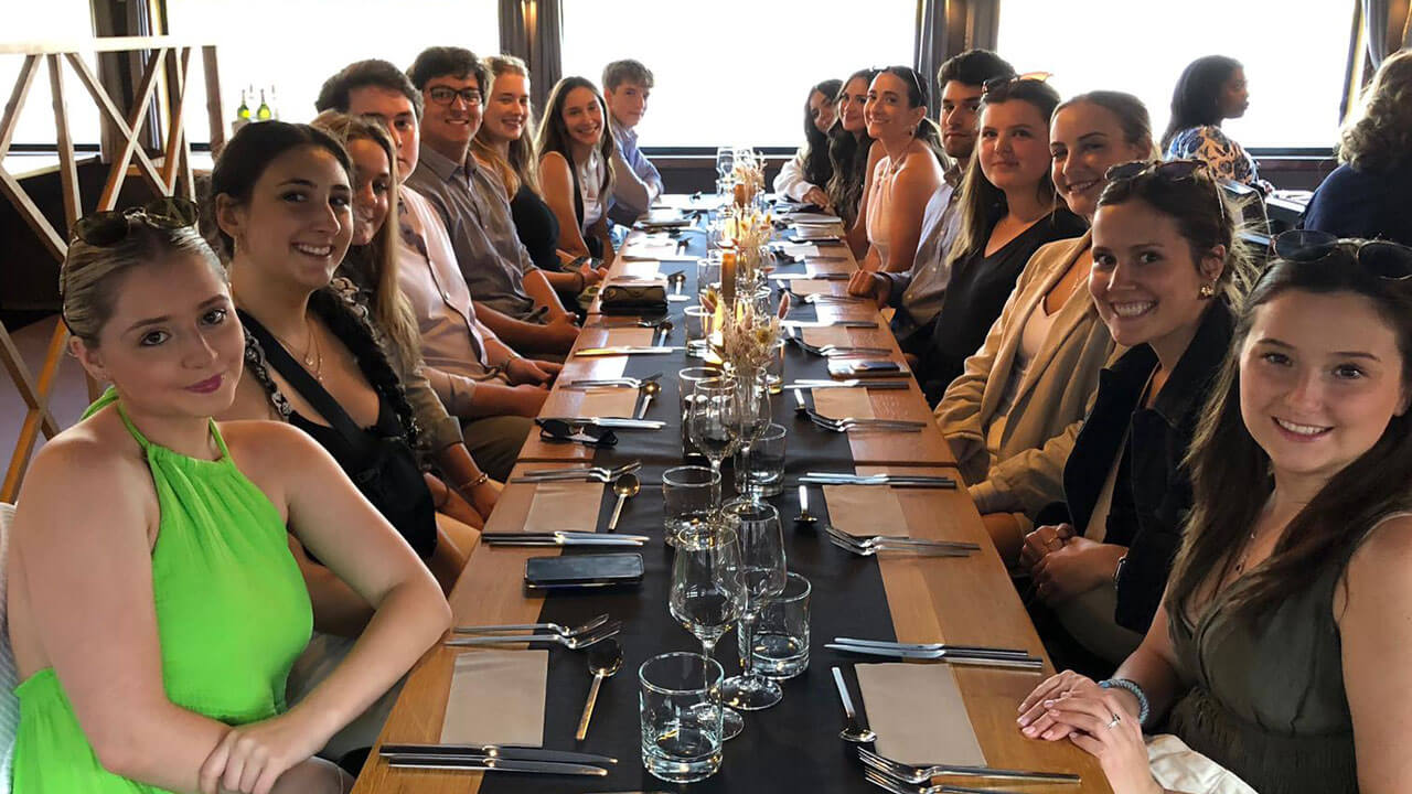 Students smiling and posing before dinner on boat tour