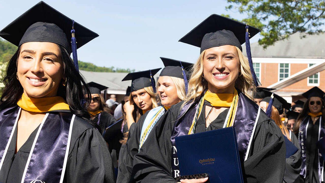 procession of graduates smiling