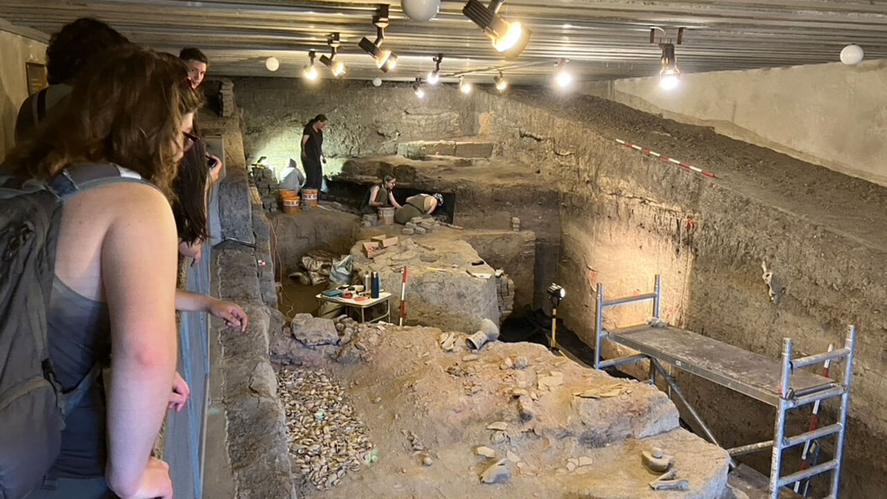 Students observe and excavation site