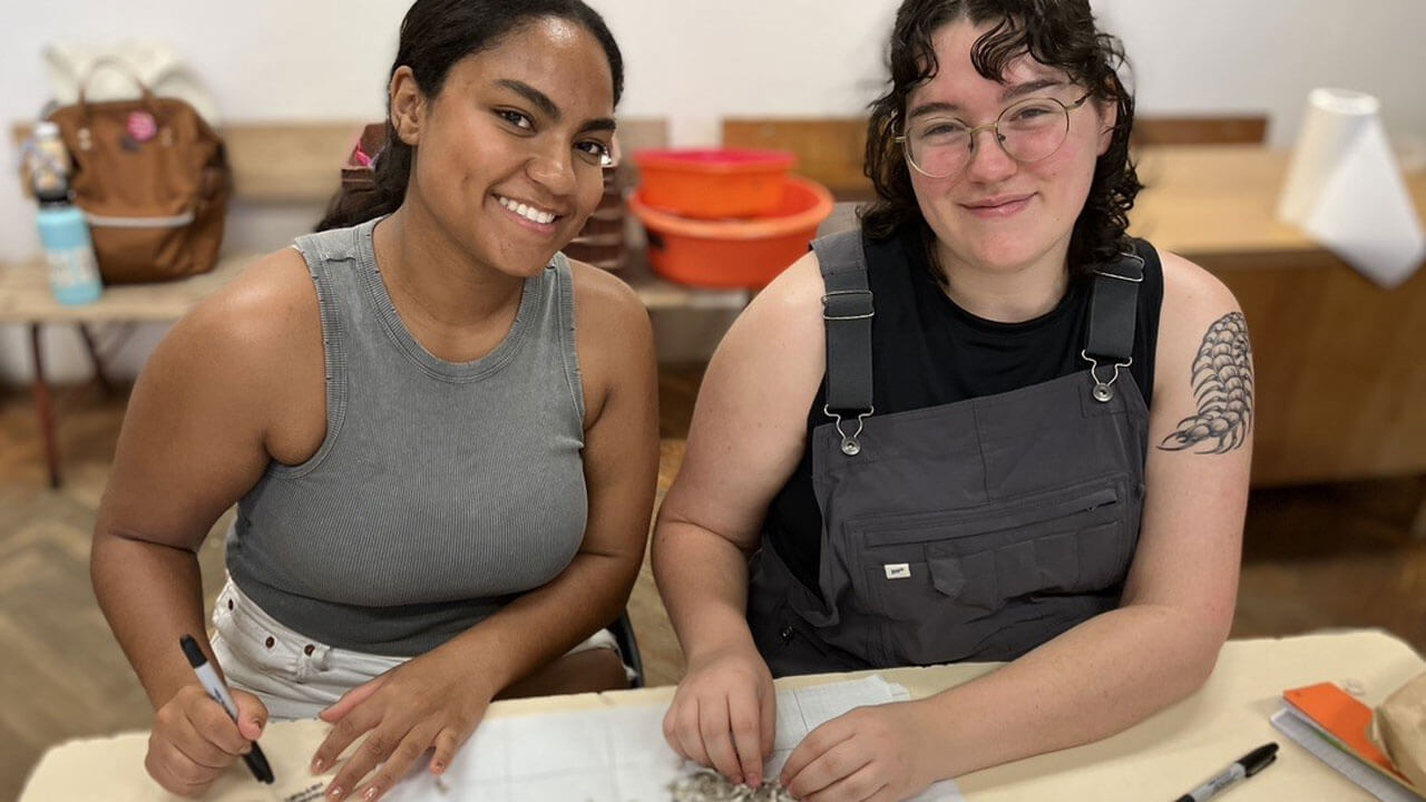 Students smiling and writing down their research