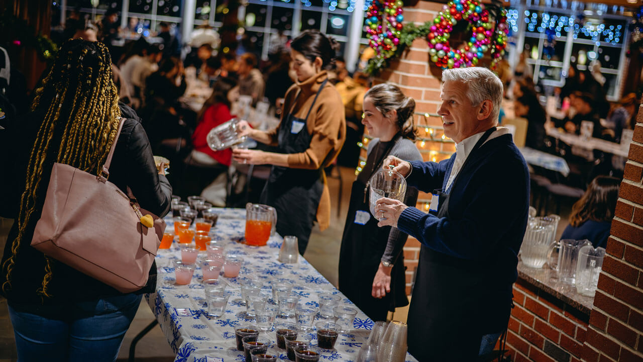 Professors serving punch in the Carl Hansen Student Center to students