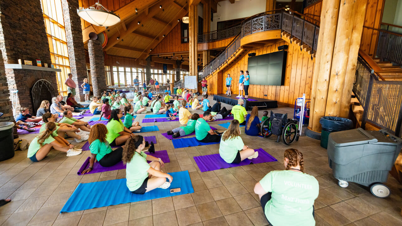 Individuals sit on yoga mats