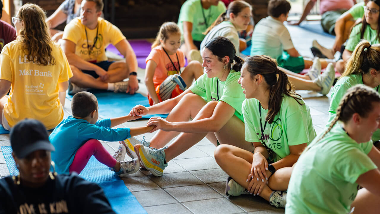 Volunteer and participants hold hands