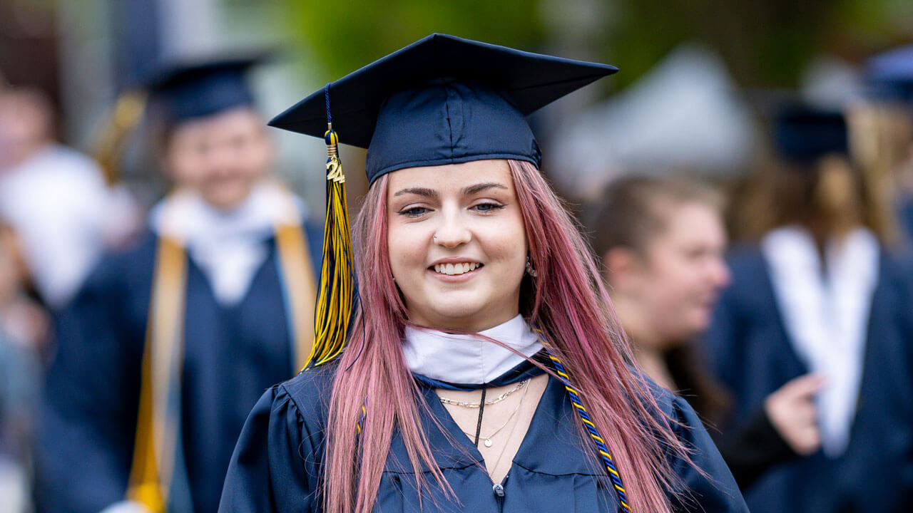 SOC graduate walking down the precession smiling