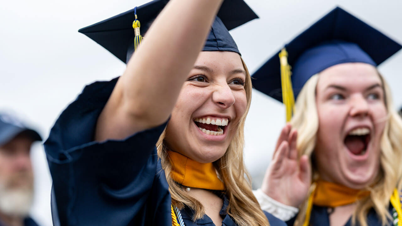 SOC Graduates smiling and cheering looking at the stage