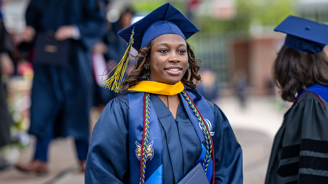 graduate smiles while looking forward