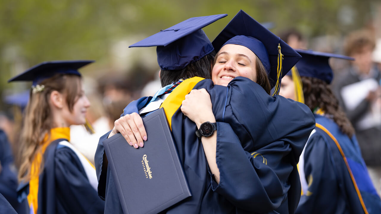 Two students hug