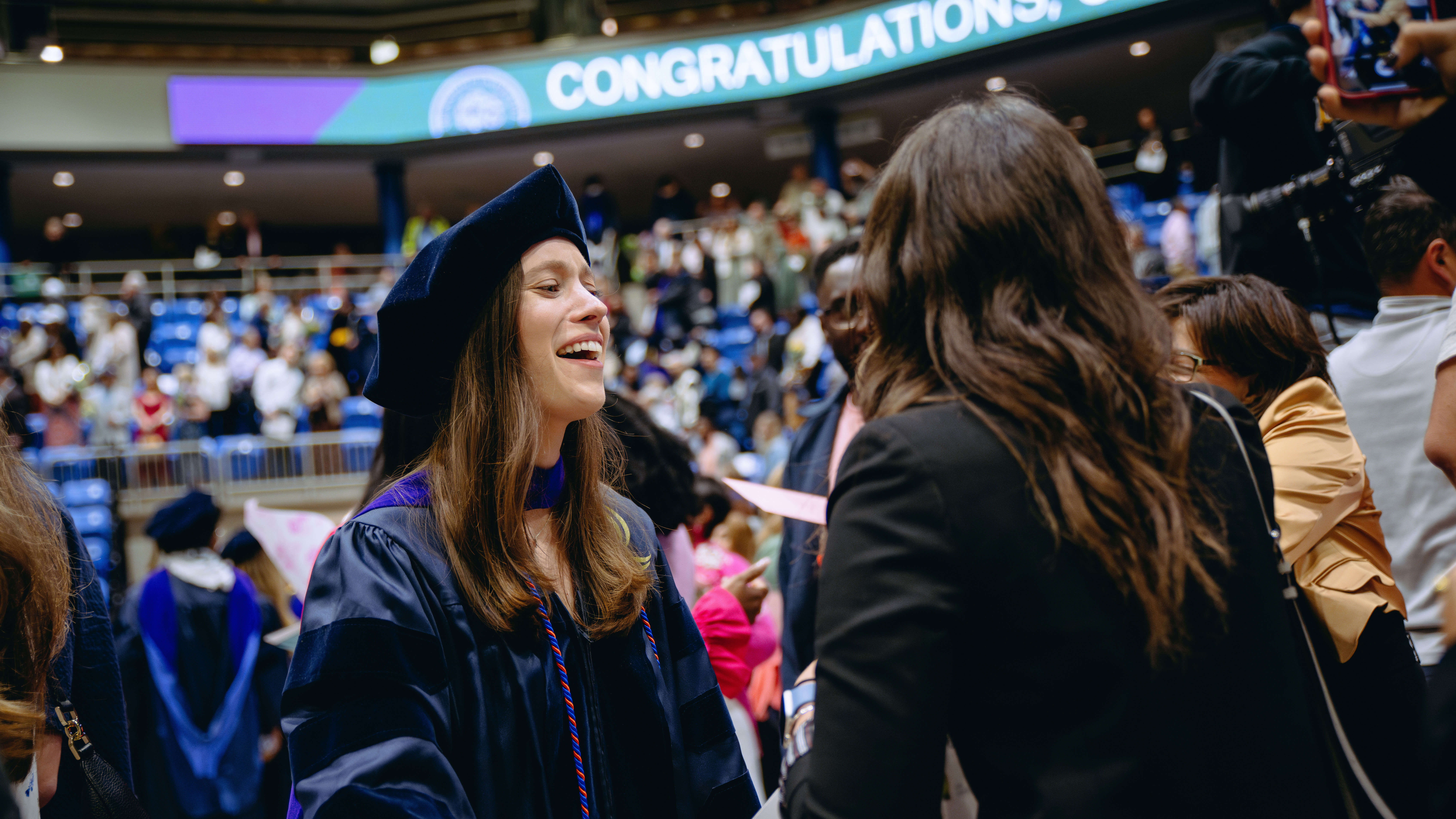 School of Law student talking to a family member in her cap and gown