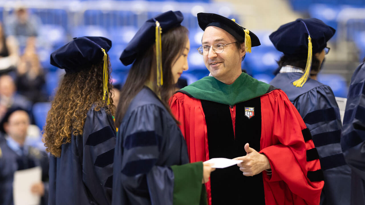 Students smiling and walking to their seats during Commencement