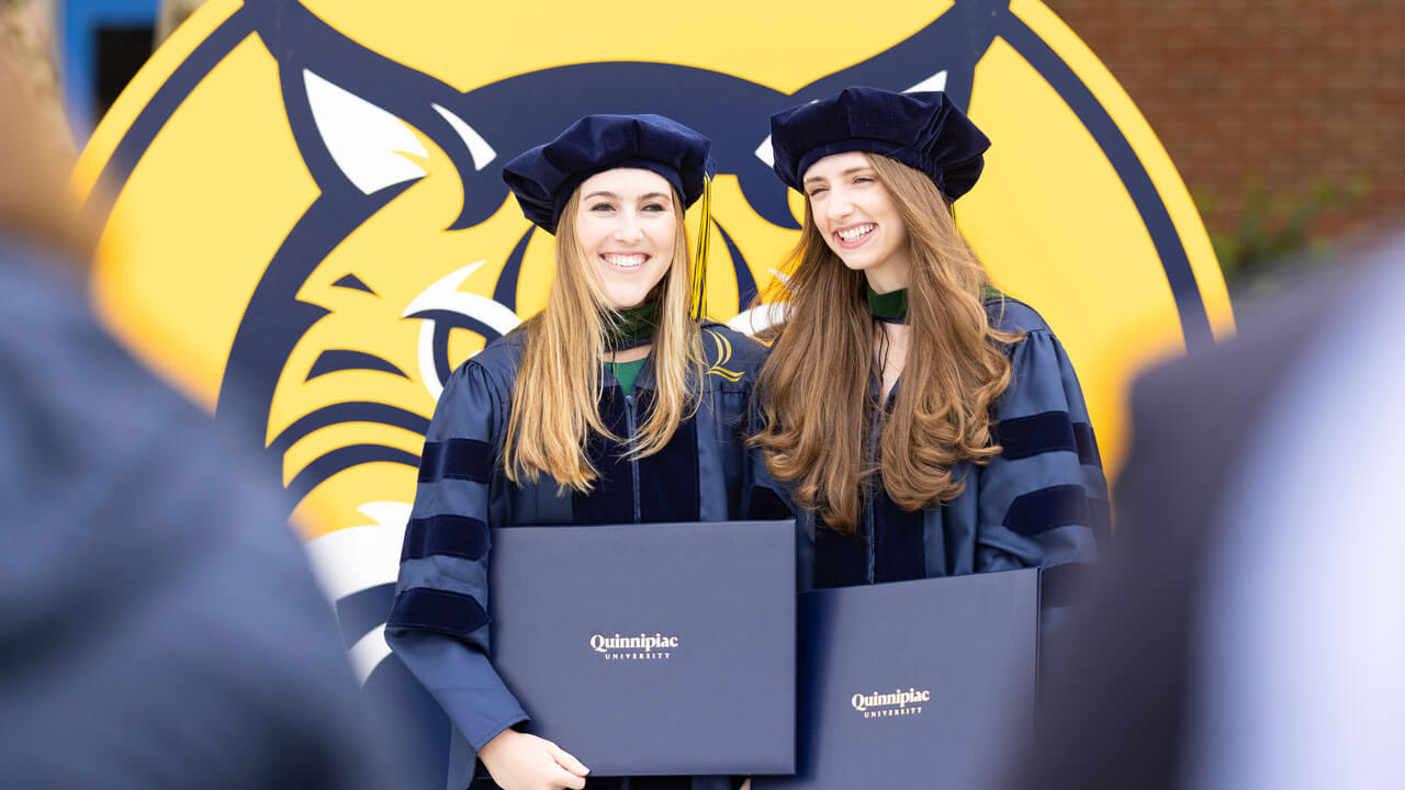 Class of 2024 medicine students smiling while holding their diplomas