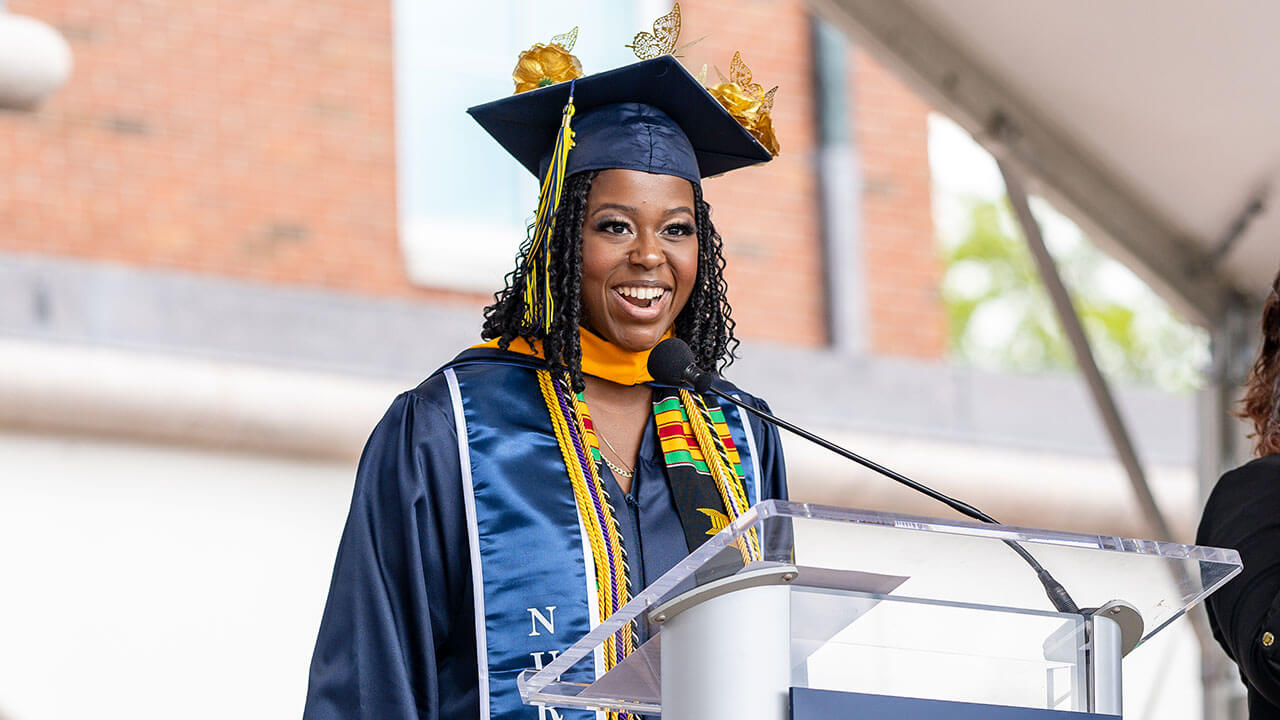 graduate speaker smiles at the auidence