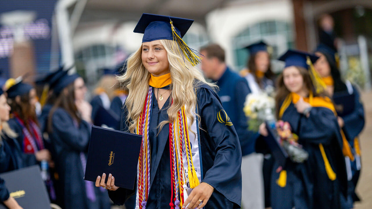 graduate smiles while walking