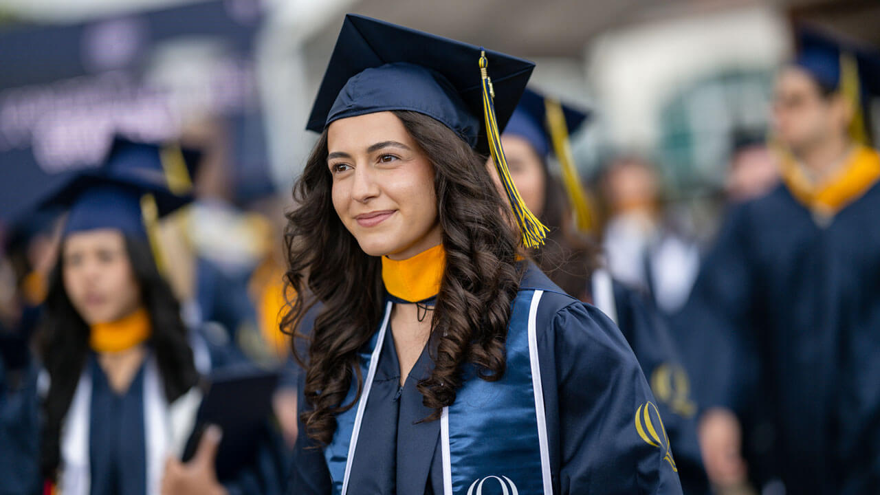 2024 graduate smiles proudly during this year's Commencement ceremony.