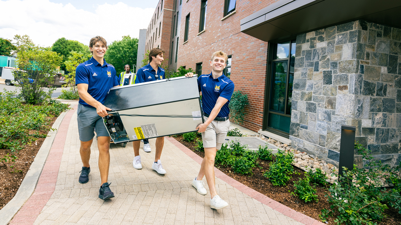 Students carrying a refrigerator