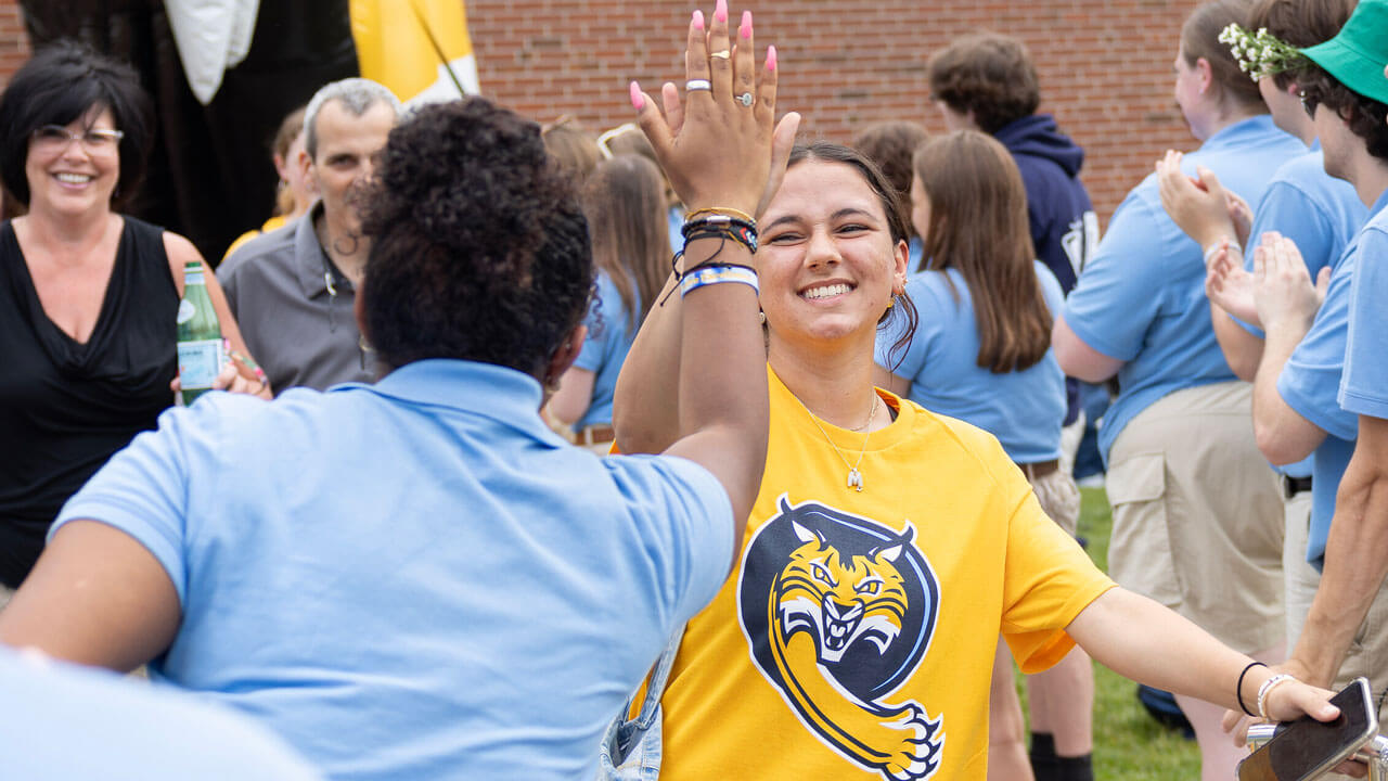 Quinnipiac first-year high-fiving their orientation leader