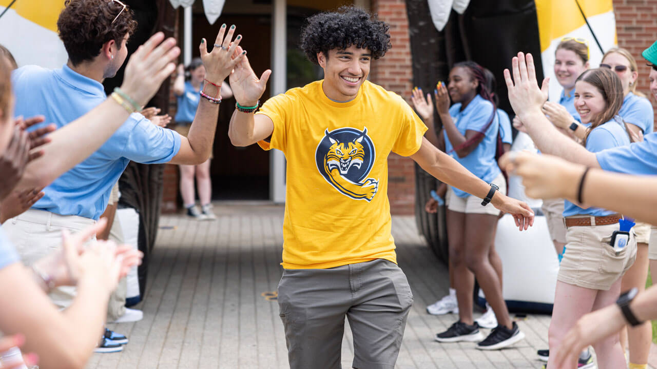 First-year student high-fiving orientation leaders