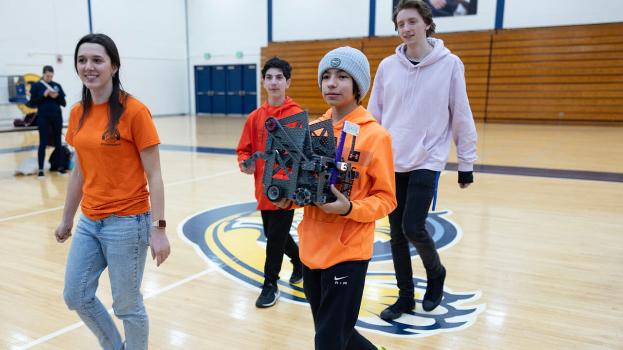 Student bringing their robot to station to particpate in competition