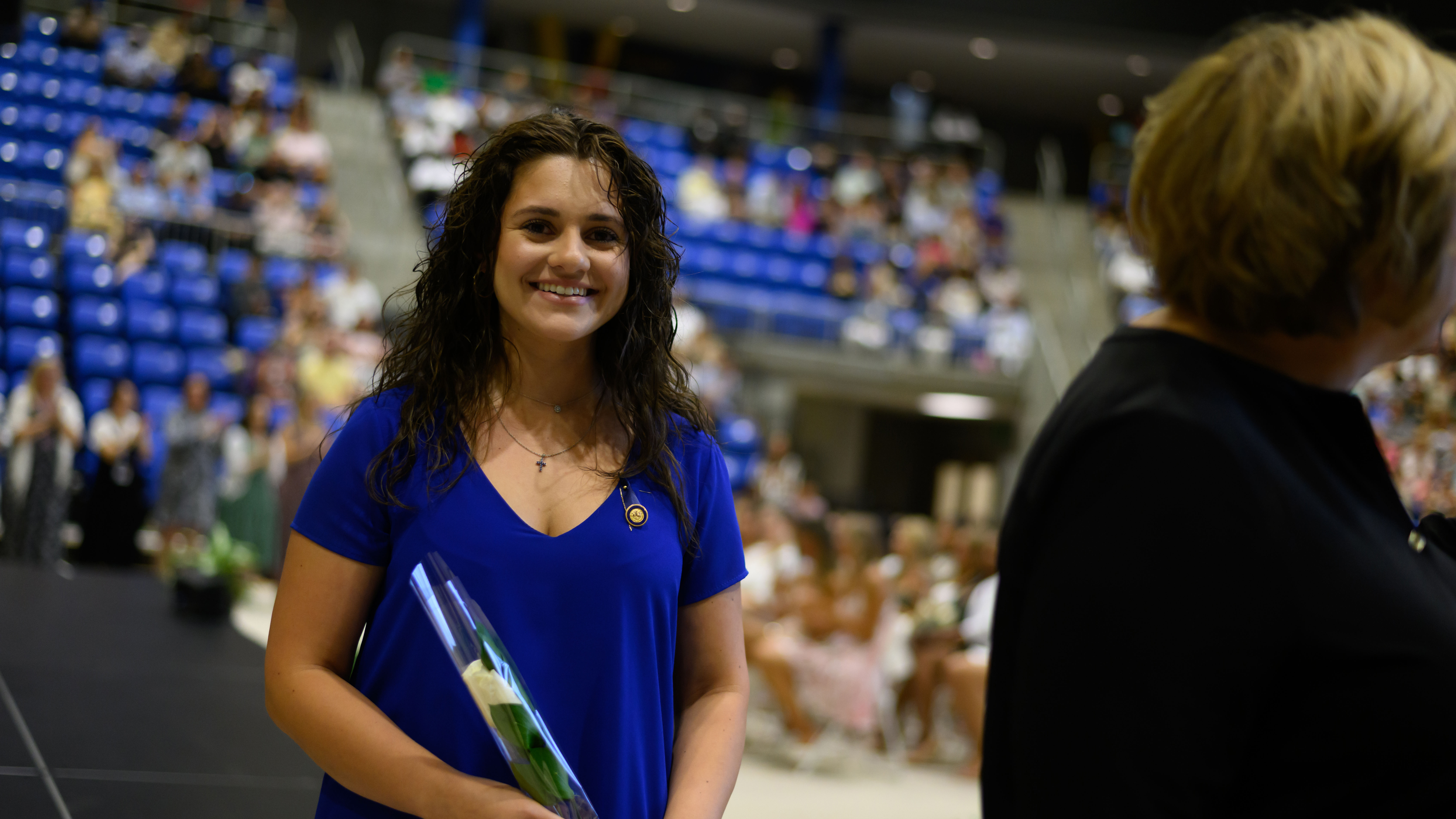 A graduate smiles with her pin on