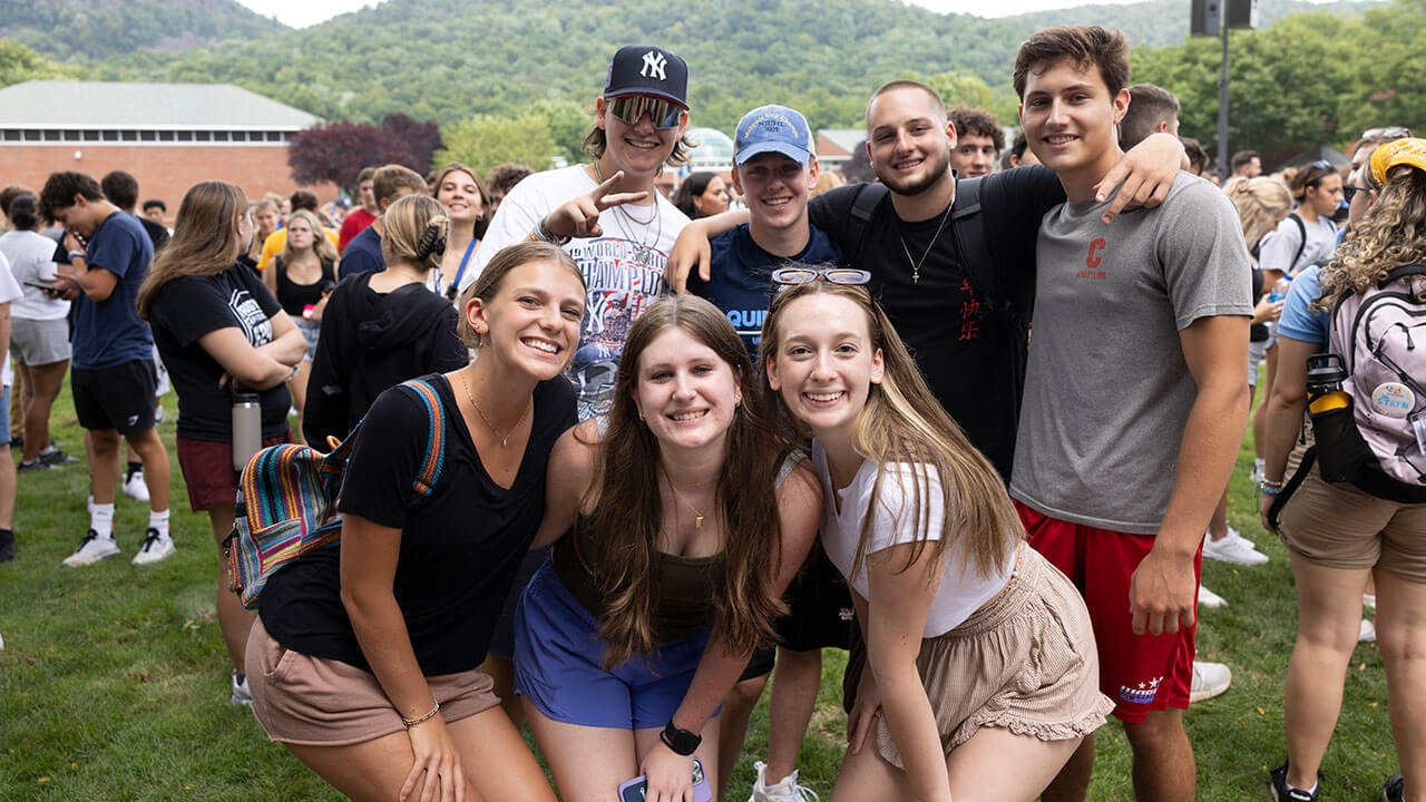 Half a dozen students pose for a photo on the quad