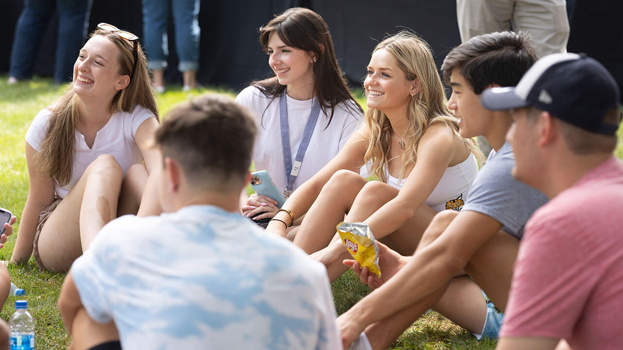 Half a dozen new students sit together and talk