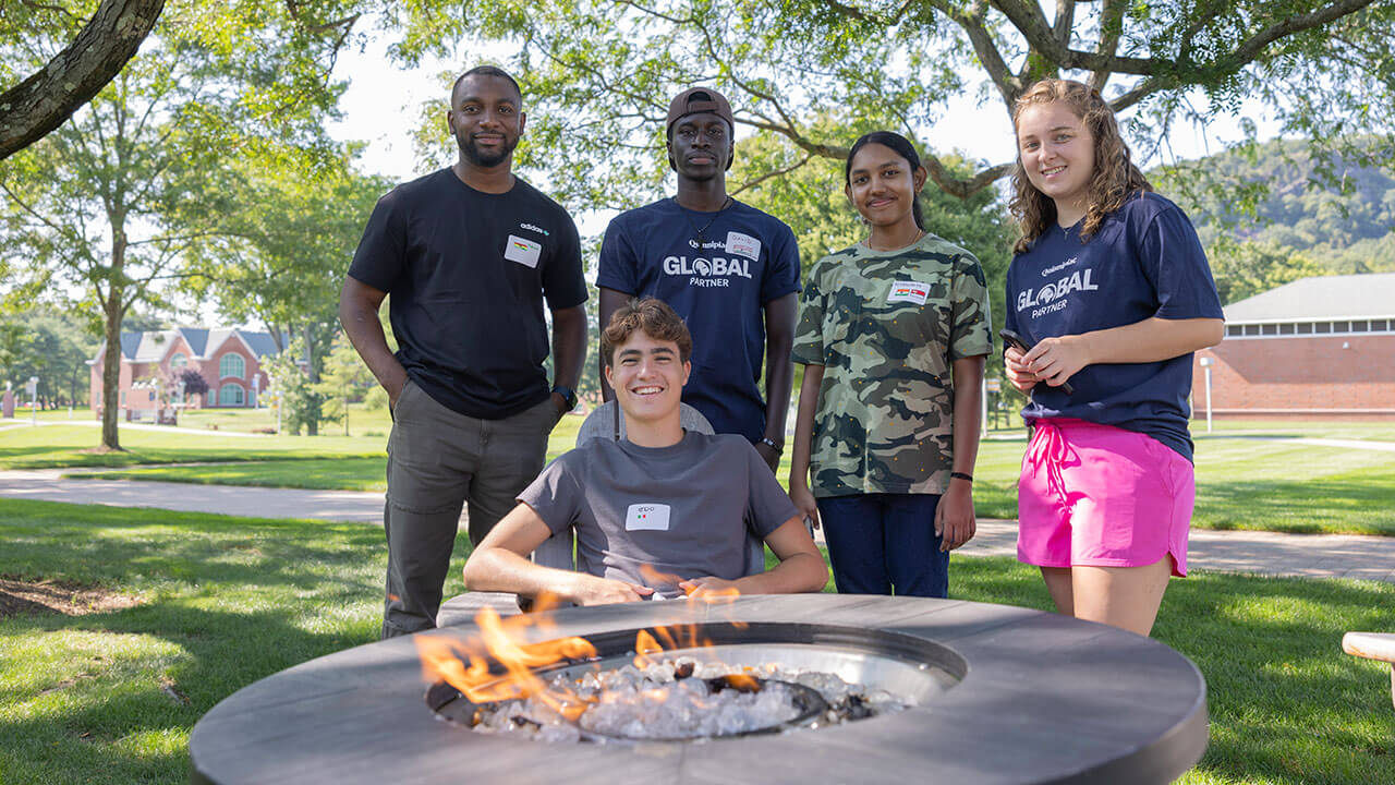 International students take a photo by the fire pit