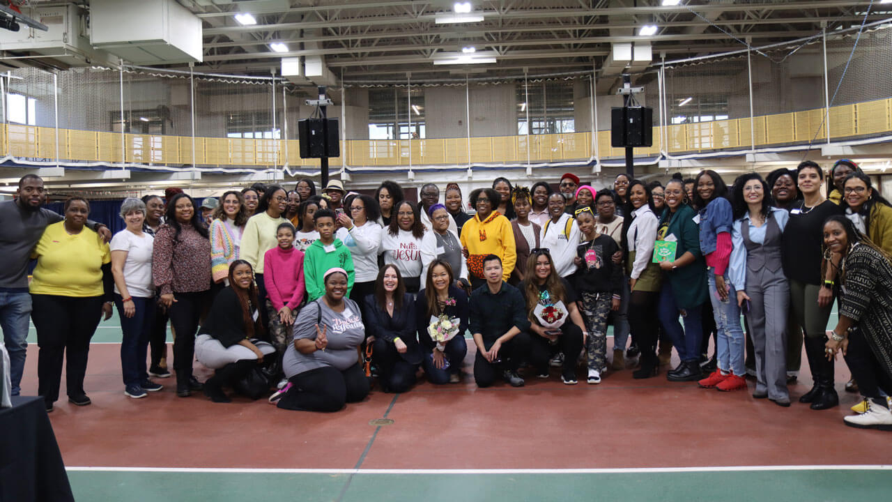 A group of business owners smile in the gymnasium.