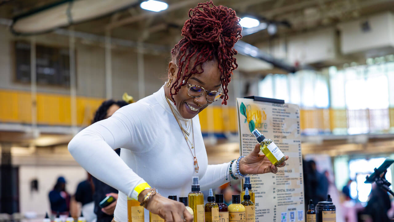 A vendor smiles as they rearrange products.