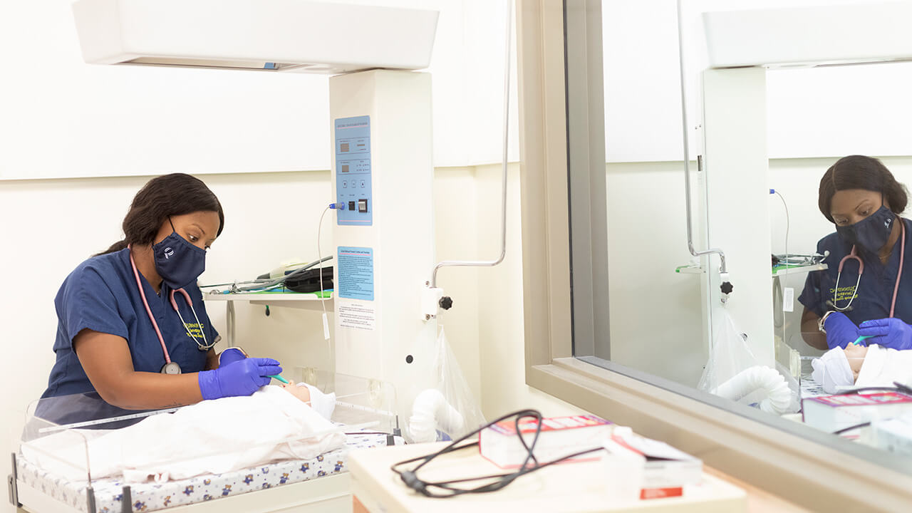 Nursing student Shaiona Williams participates in a simulation with an infant high-fidelity mannequin.