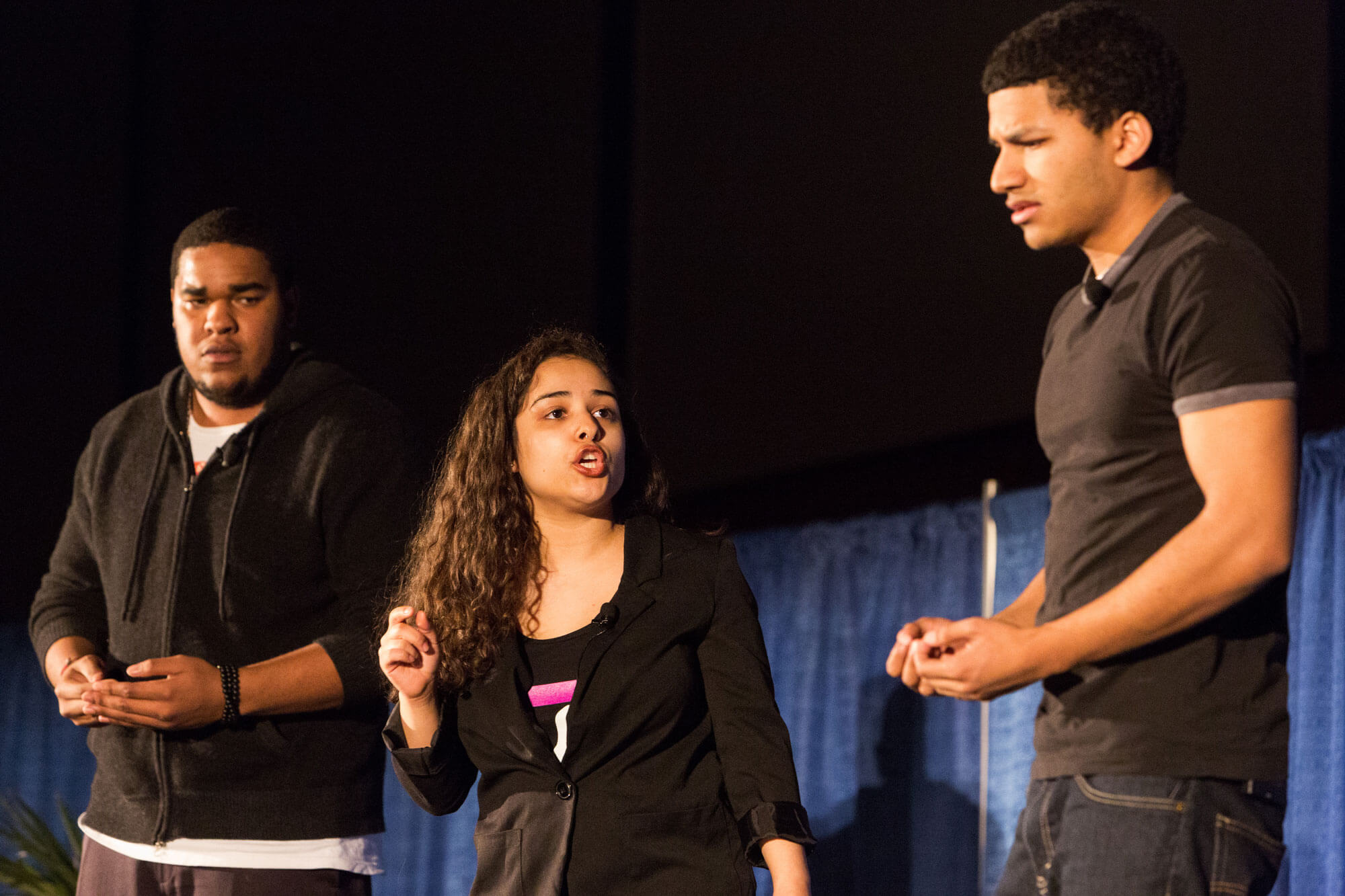 Three performers present on stage