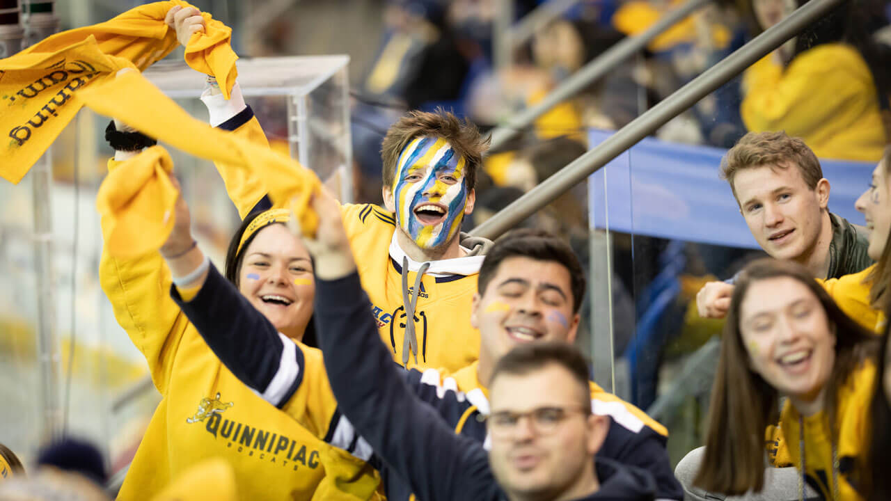 Students waving Quinnipiac towels in the air