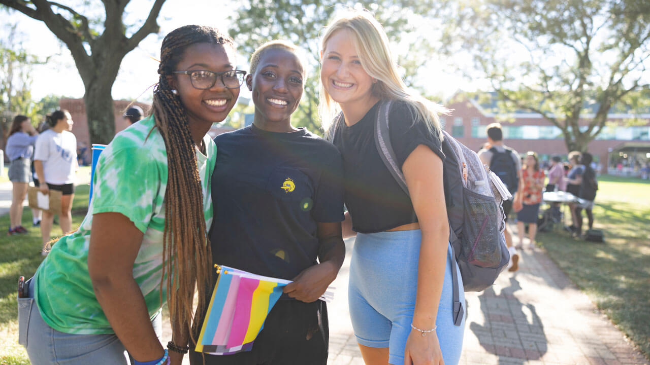 Three girls standing together smiling