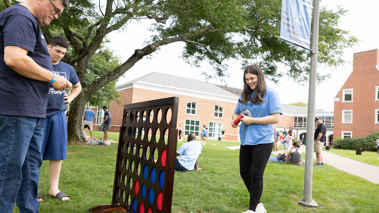 Family playing connect 4 on the lawn