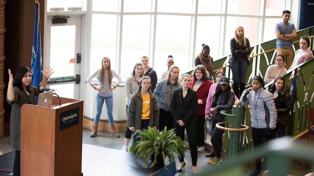 A professors speaks to a packed room of faculty and students