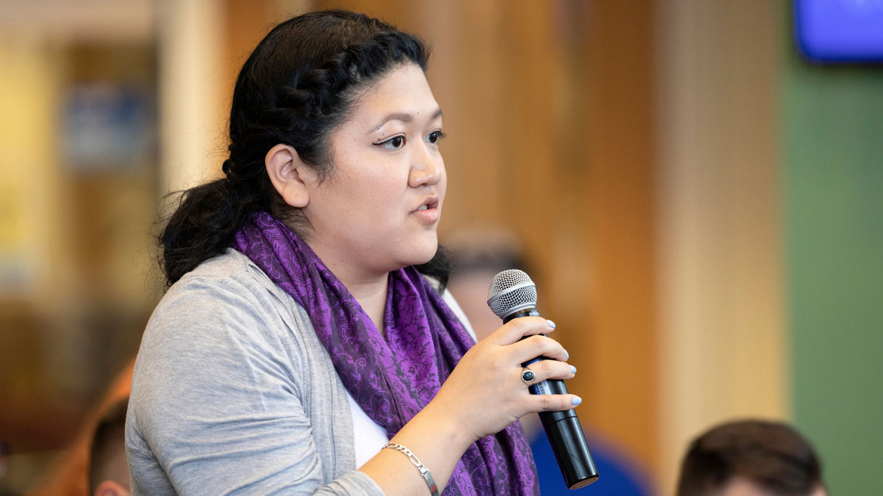 A student asks a question into a microphone