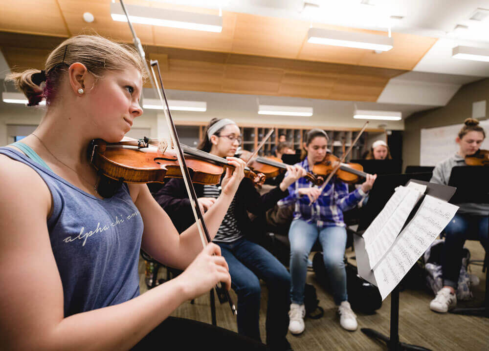 Members of the Quinnipiac Symphony Orchestra play their instruments.