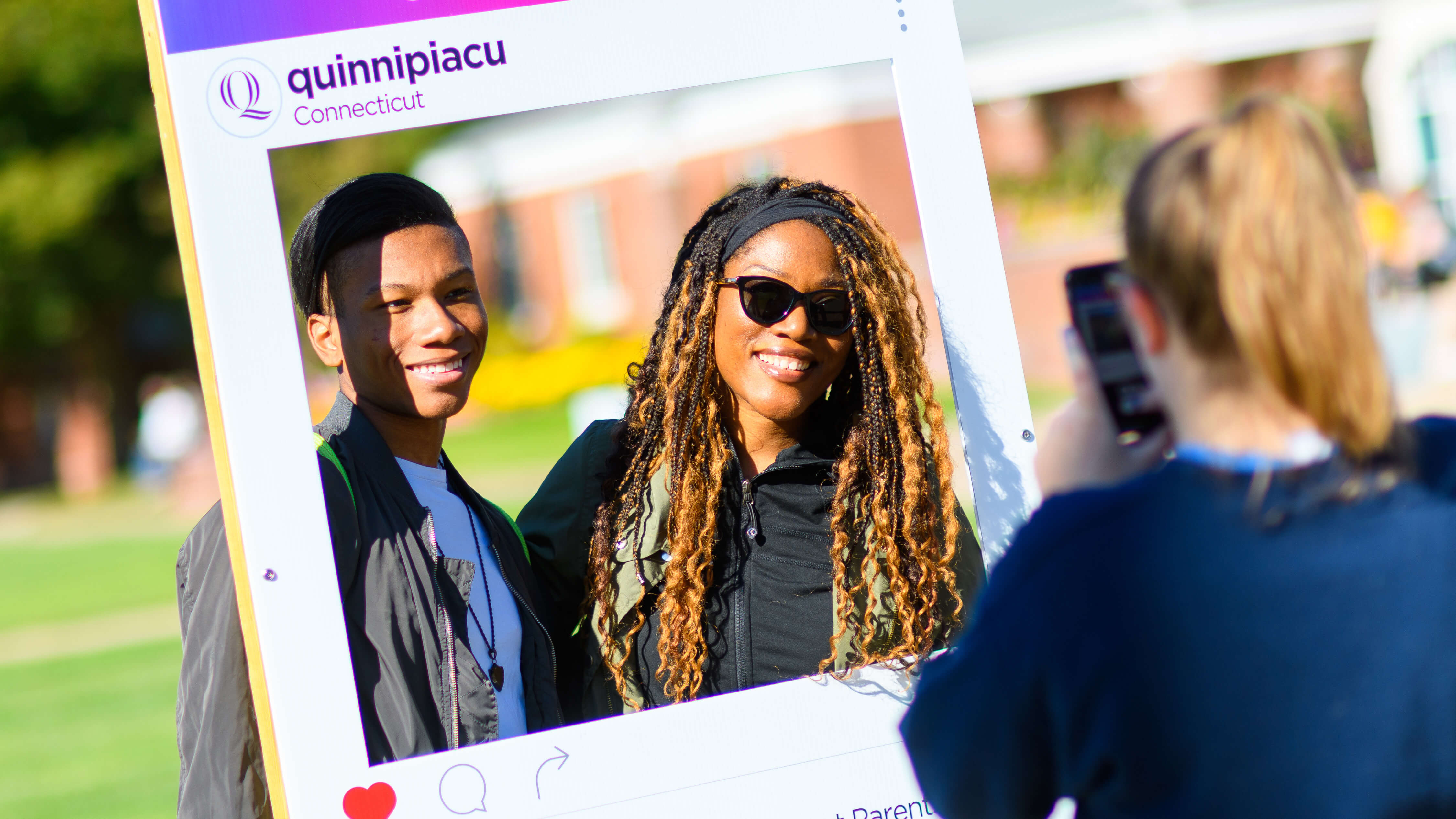 Student and family member pose for a photo on the quad