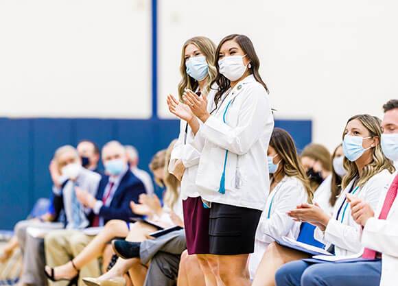 Physician Assistant students clapping at ceremony