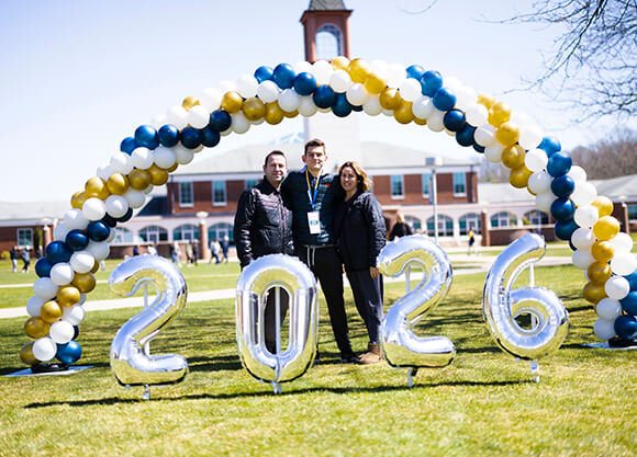 Students smile in front of 2026 balloons.