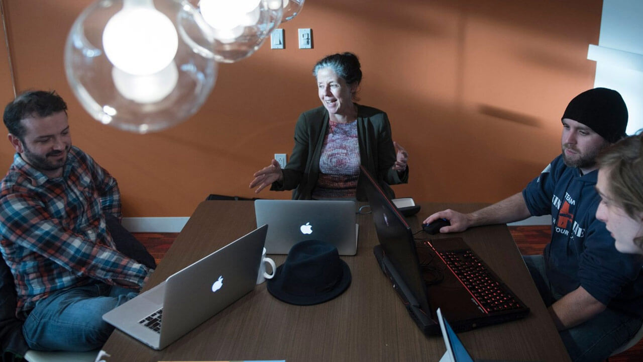 Elena Bertozzi sits at a table with 4 other students in the conference room in the Center for Innovation and Entrepreneurship