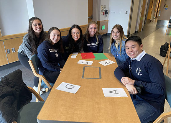 Students gather around a table