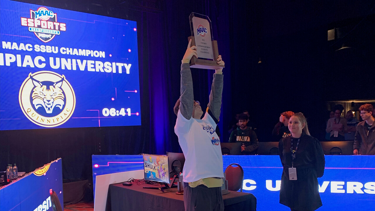 Jonathan Mason holds up the MAAC Championship trophy.