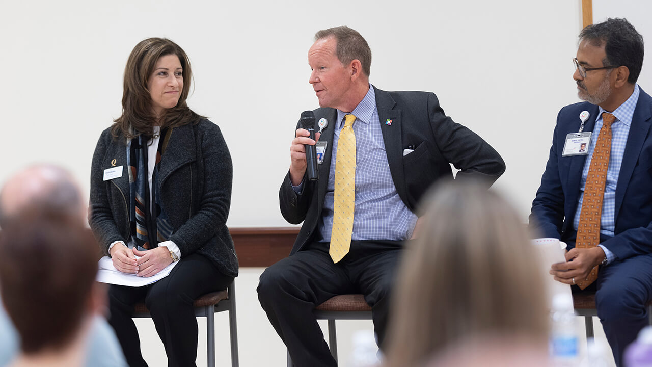 Panelists speak at an event.